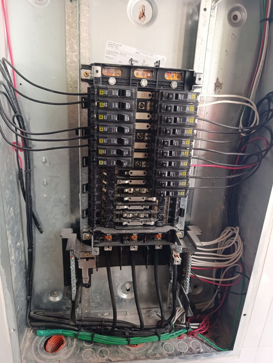Centro de carga abierto con interruptores termomagnéticos y cableado ordenado